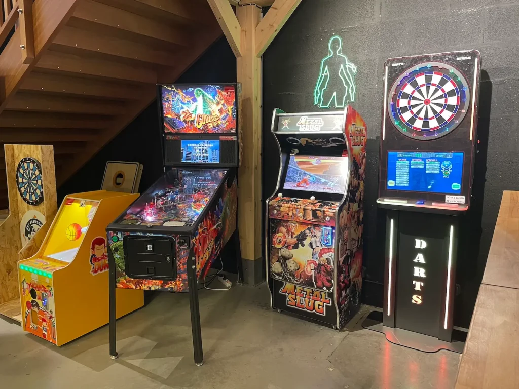 Coin jeux d'arcades composé d'un flipper, d'une cible de fléchettes. Il y a également une cible de fléchettes pour enfants et d'un jeu de lancer de ballons de basket.
